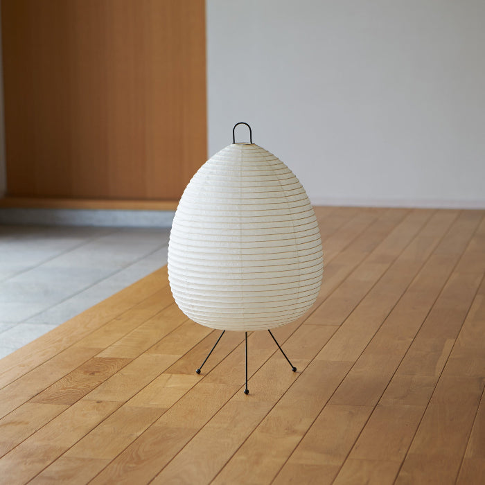 White paper lamp on a wooden floor with a minimal background