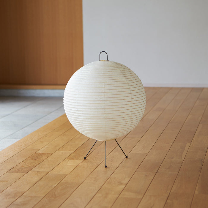 White spherical lamp on a wooden floor with a minimal background