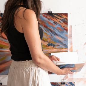Woman standing in front of abstract paintings on a wall