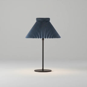 Table lamp with pleated blue shade on a white background