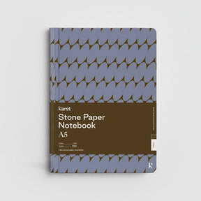 Stone Paper Notebook with blue and brown design on a light gray background