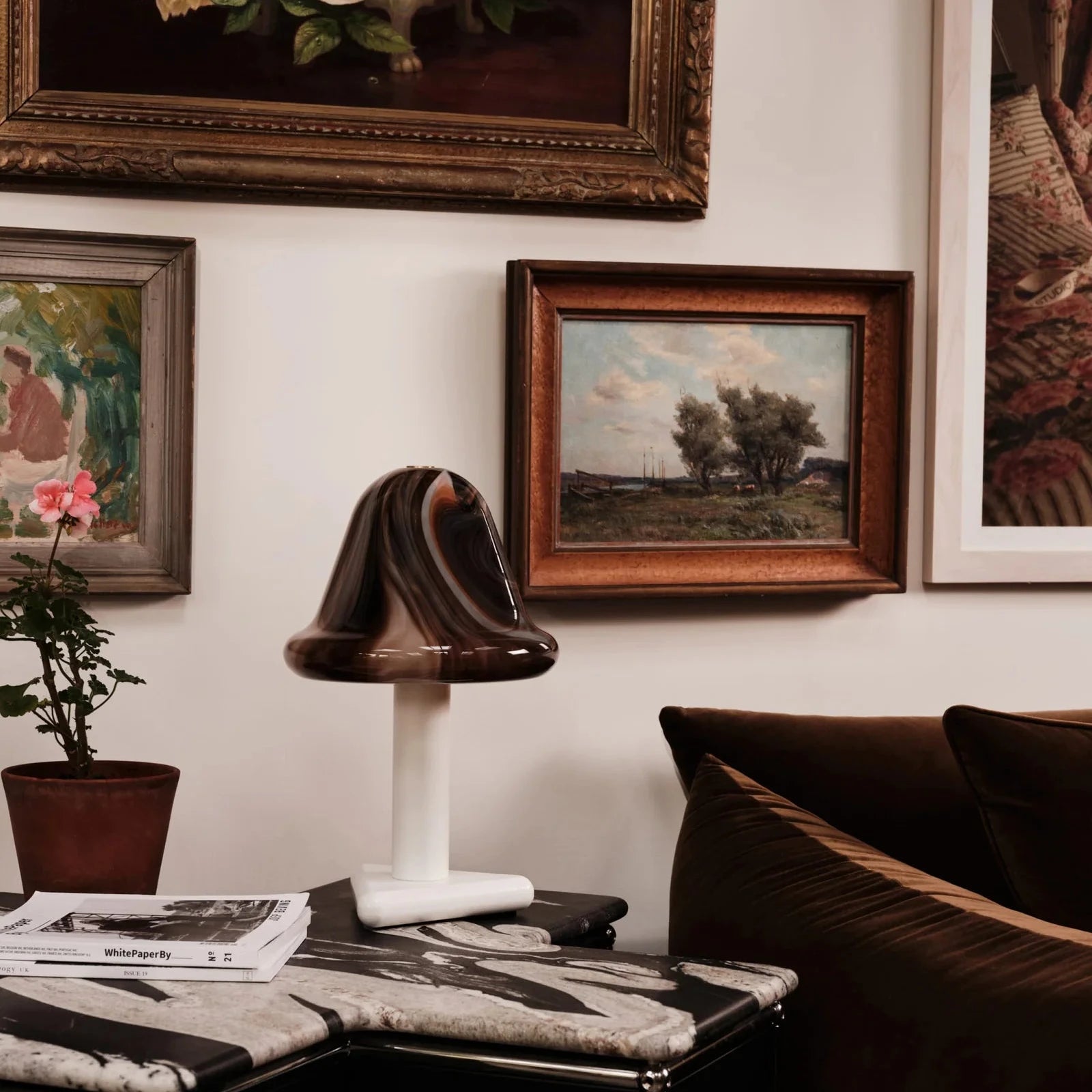 Living room with a sofa, table, and framed artwork on the wall.