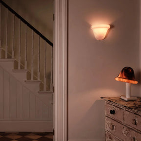 Staircase and wall sconce in a dimly lit room