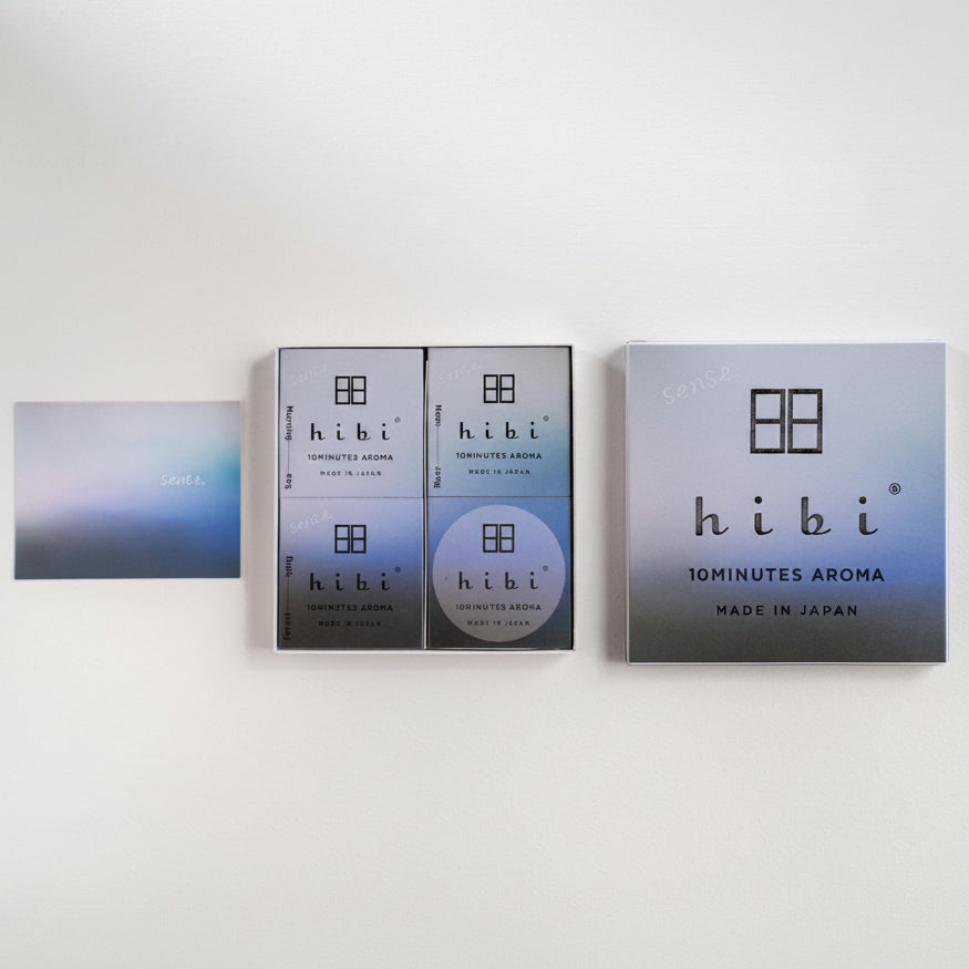 Hibi 10minutes Aroma product packaging set on a clean white background, featuring a square box, two smaller rectangular boxes, a round disc, and a small card.