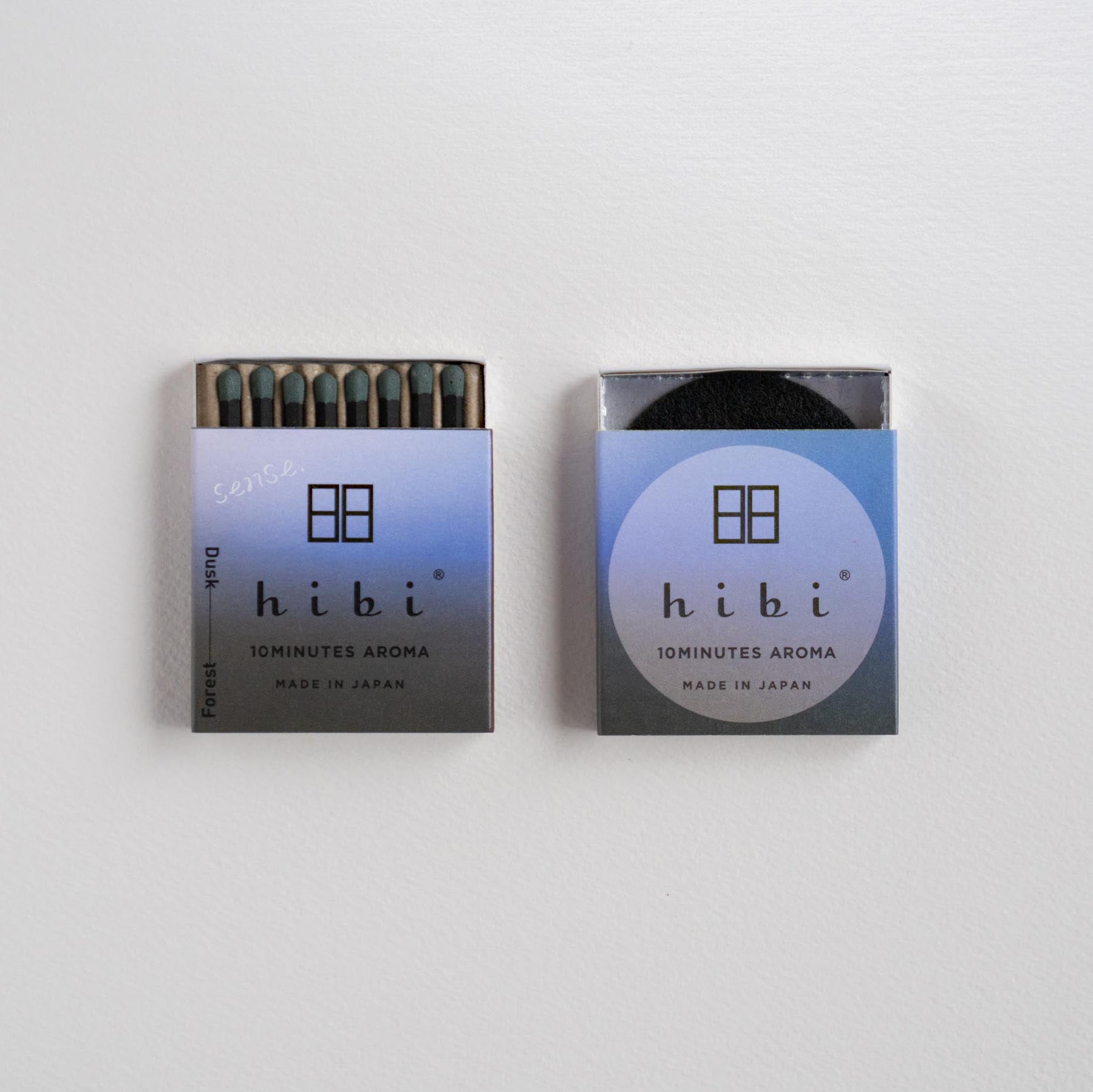Two small Hibi brand matchboxes for 'Sunlight Aroma' are shown against a plain white background, one open to reveal dark matches and one closed.