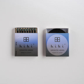 Two small Hibi brand matchboxes for 'Sunlight Aroma' are shown against a plain white background, one open to reveal dark matches and one closed.