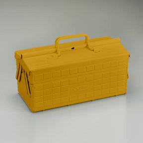 Mustard yellow Toyo steel cantilever toolbox, closed, three-quarter view showing embossed grid sides, folded arms, and top carry handle.