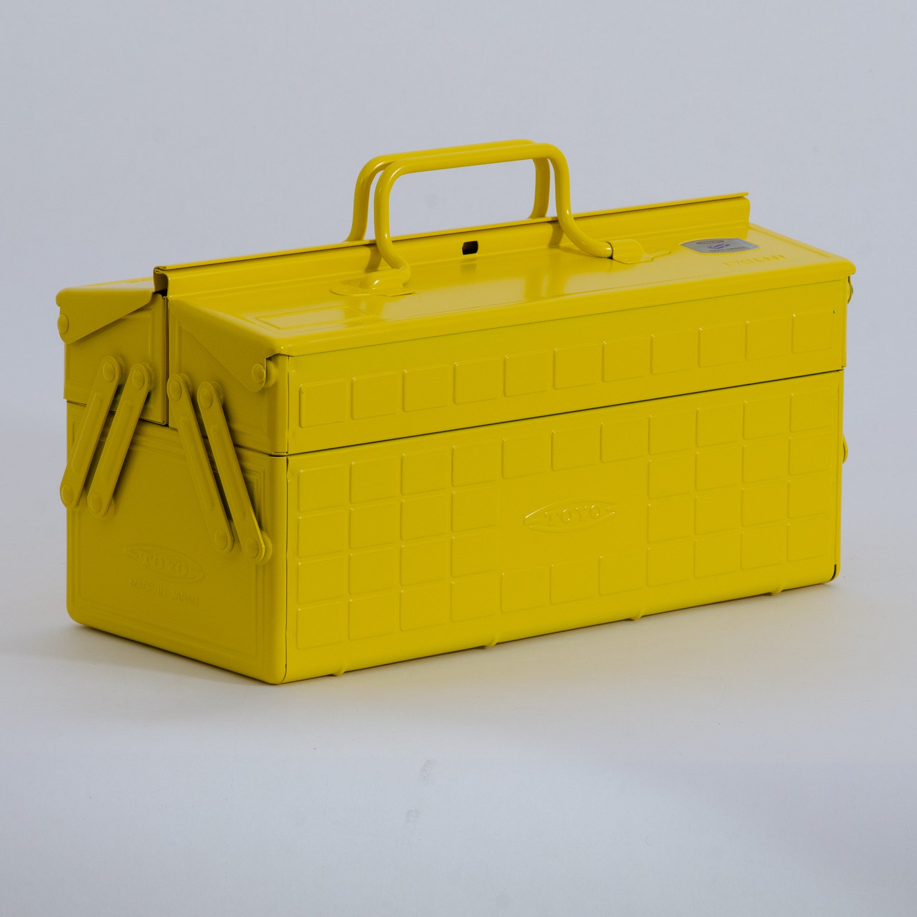 Yellow Toyo steel cantilever toolbox, closed, three-quarter front view with folded side arms and top carry handle.