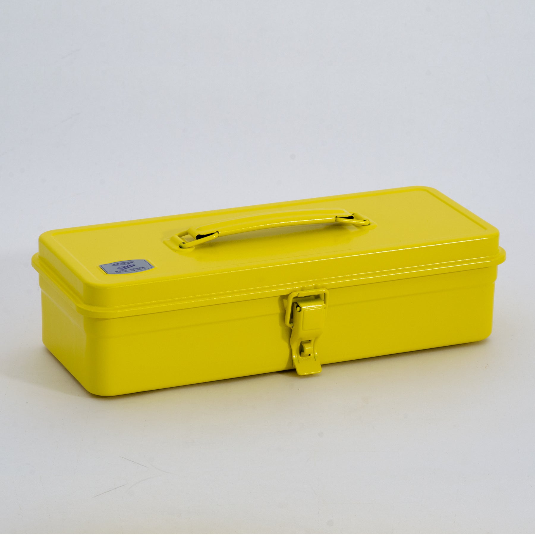 Yellow Toyo Steel metal toolbox with top carry handle and single front latch, shown closed on a light gray studio background.