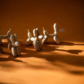 Wooden dog sculptures arranged in a line on an orange surface with a warm glow.