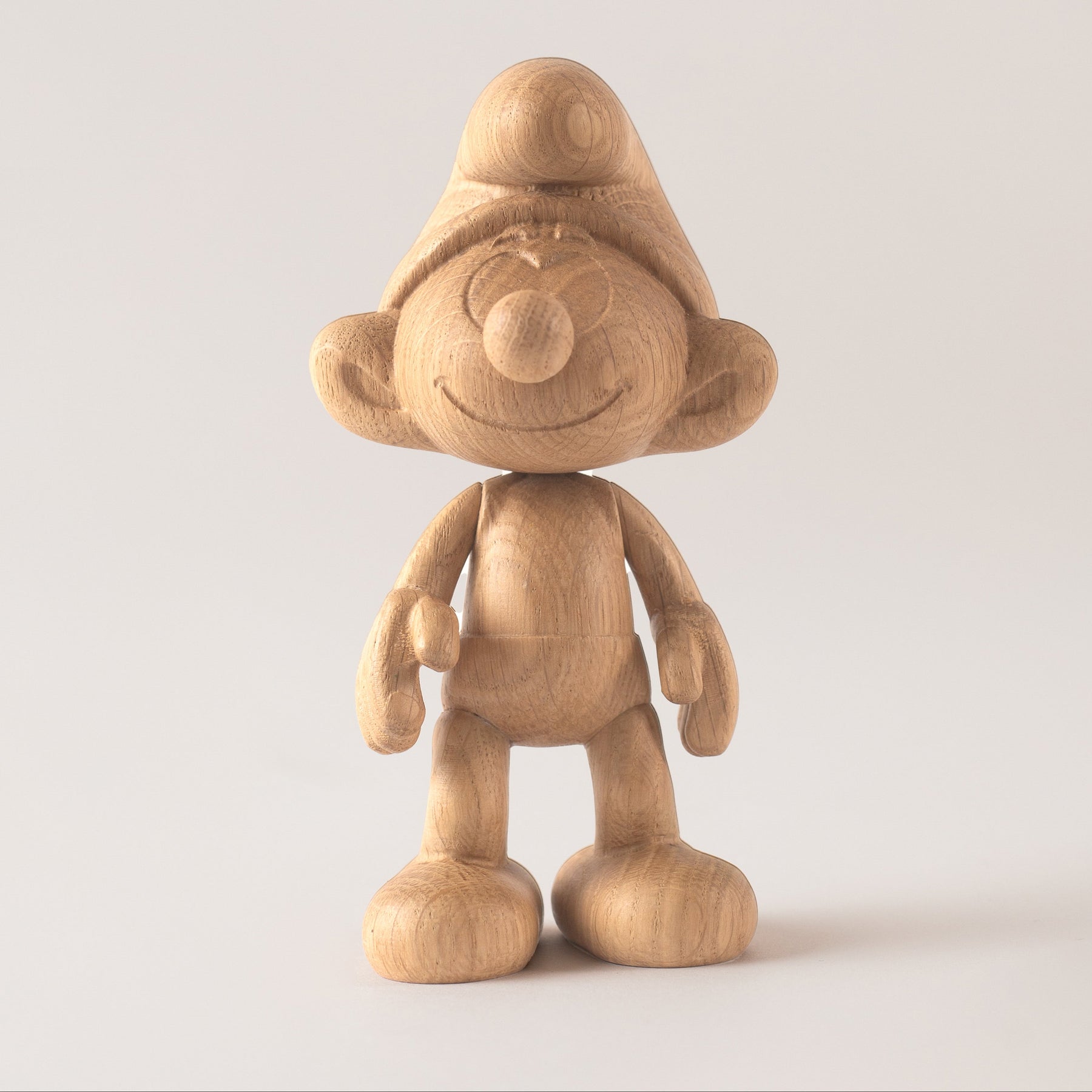 Wooden Smurf figurine on a light gray background