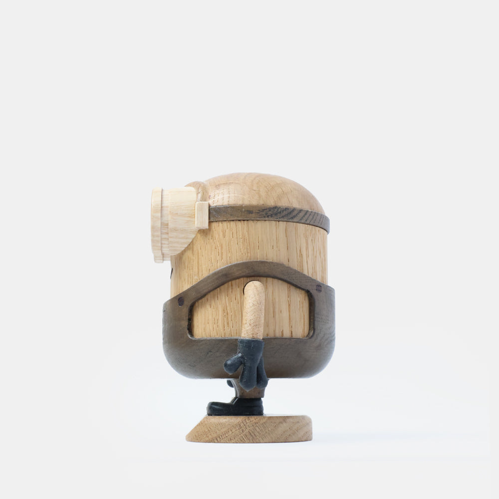 Wooden Minion character figurine with carved goggles, smiling face, gray overalls, black gloves, and boots, standing on a round wooden base labeled “Bob”.
