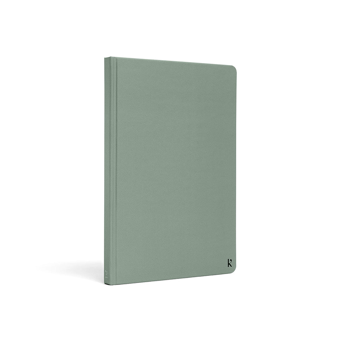 Karst A5 stone paper notebook with a sage green hard cover, shown at a three-quarter angle on a white background, featuring a clean minimalist design with a subtle embossed Karst logo in the lower corner.