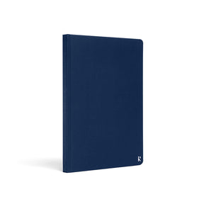 Karst A5 stone paper notebook with a navy blue hard cover, shown at a three-quarter angle on a white background, featuring a clean minimalist design and a subtle embossed Karst logo in the lower corner.