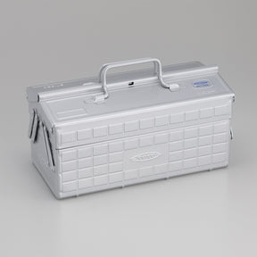 Silver Toyo steel cantilever toolbox, closed, shown at a three-quarter angle with embossed grid panels, folded side arms, and a fixed top handle on a neutral studio background.