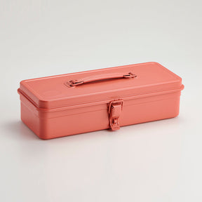 Coral-colored Toyo Steel metal toolbox with a smooth rectangular form, glossy powder-coated finish, integrated top handle, and single front latch, photographed closed against a neutral light background.