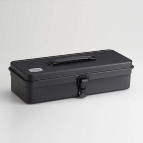 Black Toyo Steel T-320 metal toolbox with a matte powder-coated finish, rectangular profile, folding top handle, and single front latch, shown closed against a clean light gray background.