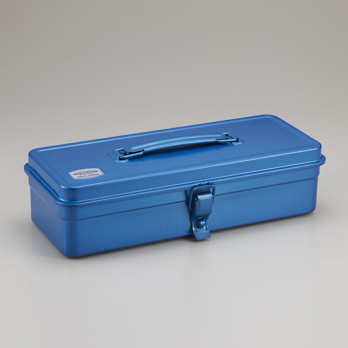Blue Toyo Steel metal toolbox with a slim rectangular shape, smooth enamel finish, top carry handle, and single front latch, shown closed on a neutral studio background.