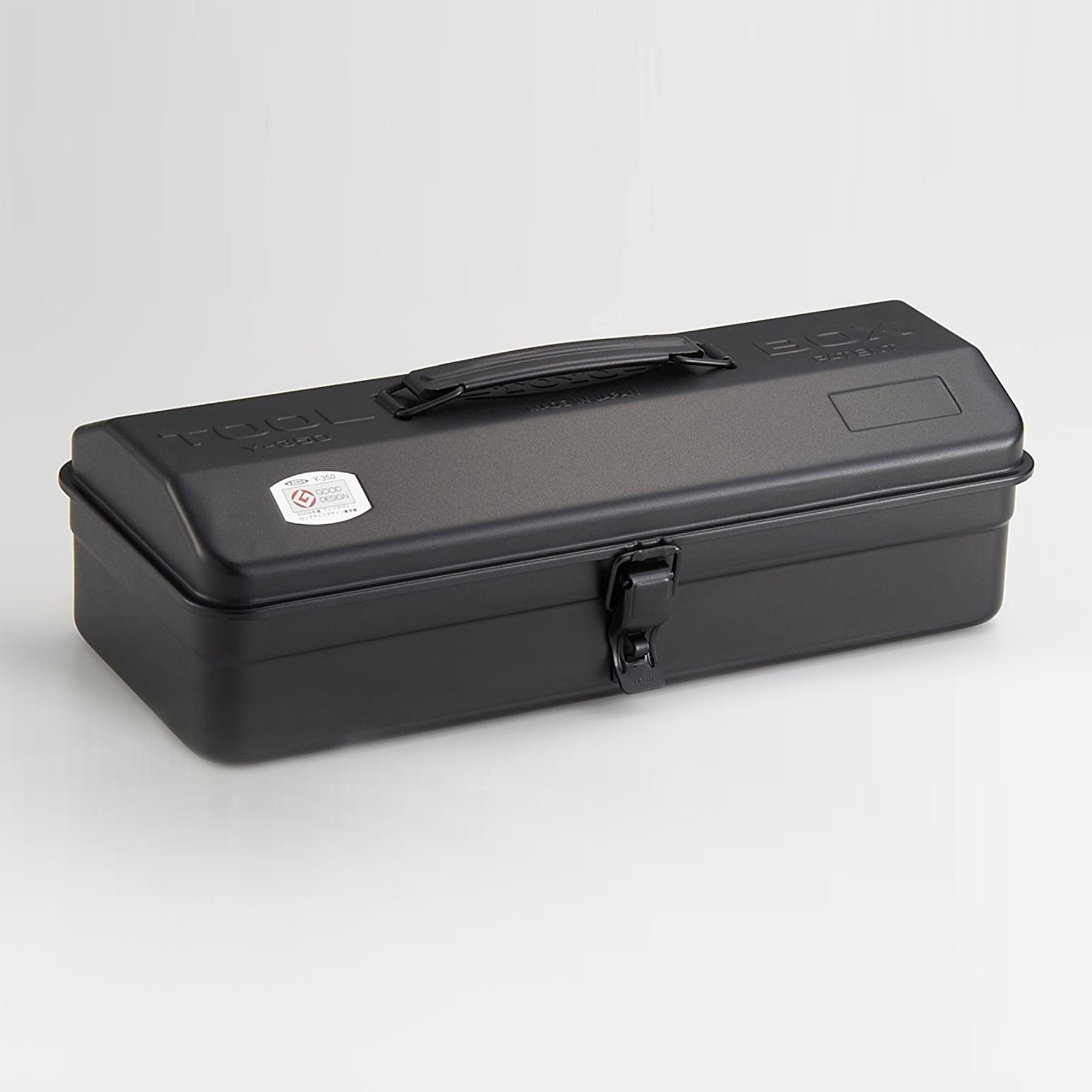 Black Toyo Y-350 steel toolbox with matte finish, elongated rectangular shape, integrated top handle, and single front latch, shown closed on a light neutral studio background.
