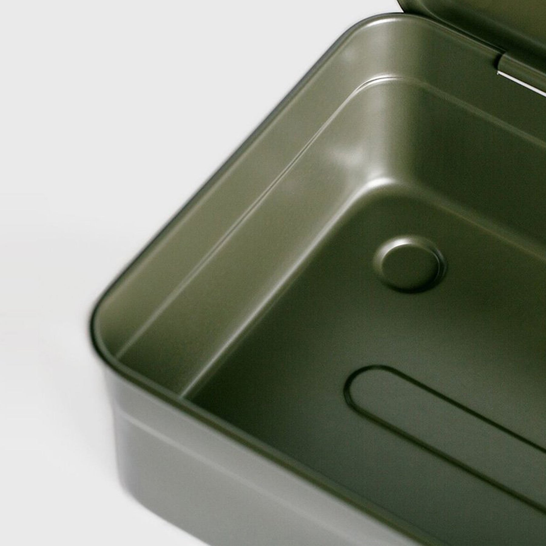 Close-up detail of an open military green Toyo Steel Y-350 toolbox, highlighting the smooth rounded interior corner, embossed metal contours, and durable steel finish.