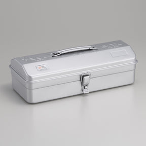 Silver Toyo Y-350 steel toolbox with matte metallic finish, rounded rectangular lid, integrated top handle, and single front latch, shown closed on a neutral gray studio background.