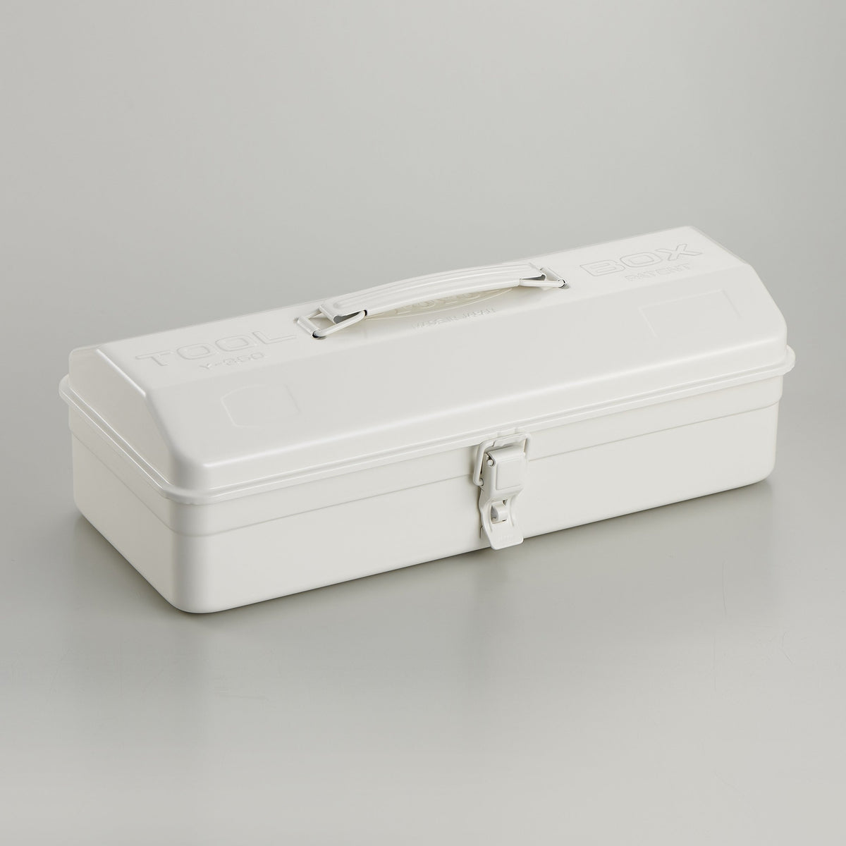 White Toyo Y-350 steel toolbox with smooth matte finish, rounded rectangular lid, integrated top handle, and single front latch, photographed closed on a light gray studio background.