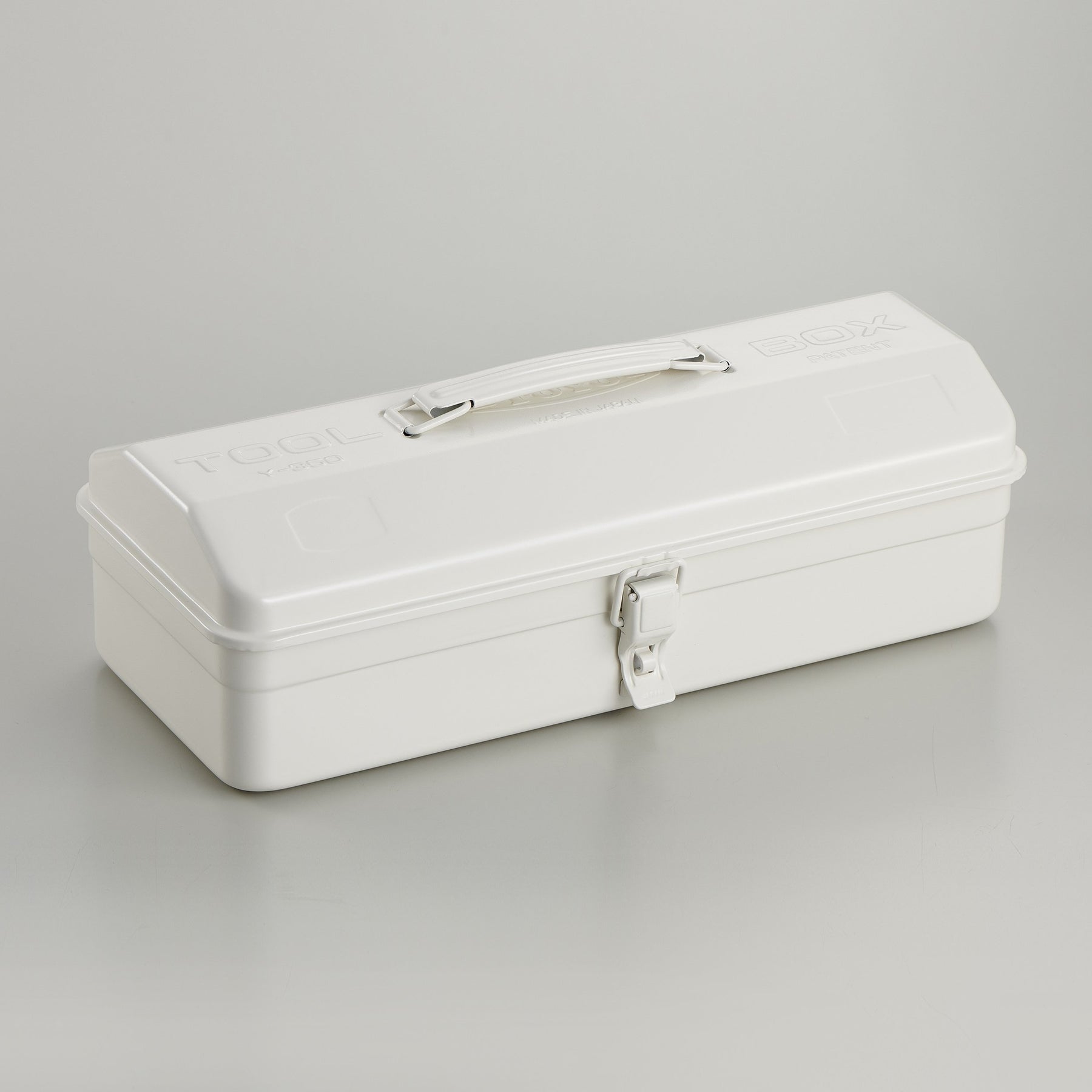 White Toyo Y-350 steel toolbox with smooth matte finish, rounded rectangular lid, integrated top handle, and single front latch, photographed closed on a light gray studio background.