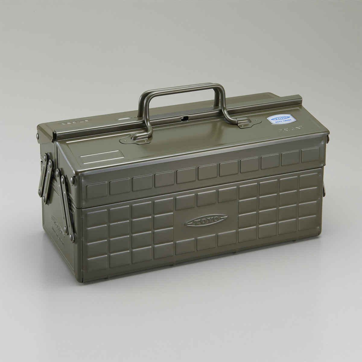 Military green Toyo steel cantilever toolbox, closed, shown at a three-quarter angle with embossed grid panels, folded side arms, and a fixed top handle on a neutral studio background.